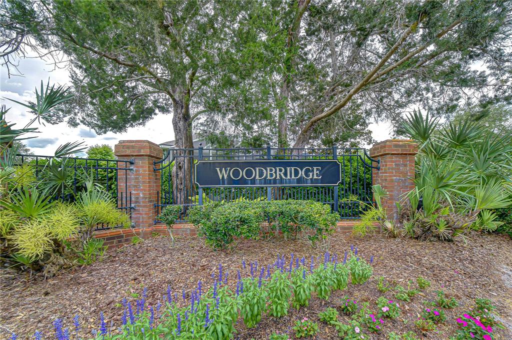 A screened-in patio with gray flooring, outdoor furniture, and a view of trees — 9815 GINGERWOOD DRIVE, TAMPA, FL