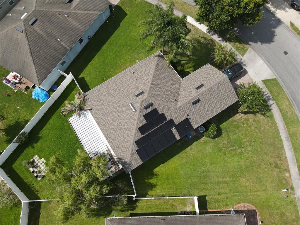 An aerial view of a house with solar panels on the roof and a backyard — 1710 PLANTATION POINTE DRIVE, ORLANDO, FL