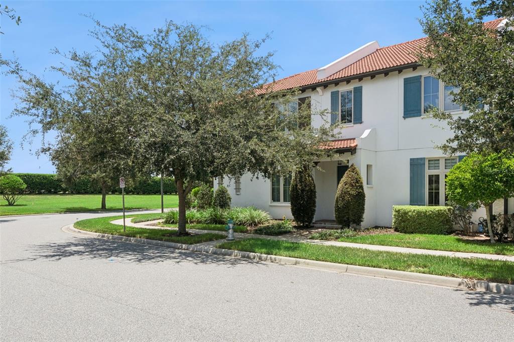 A two-story white stucco townhouse features a red tile roof and blue window shutters — 8932 BISMARCK PALM DRIVE, WINTER GARDEN, FL