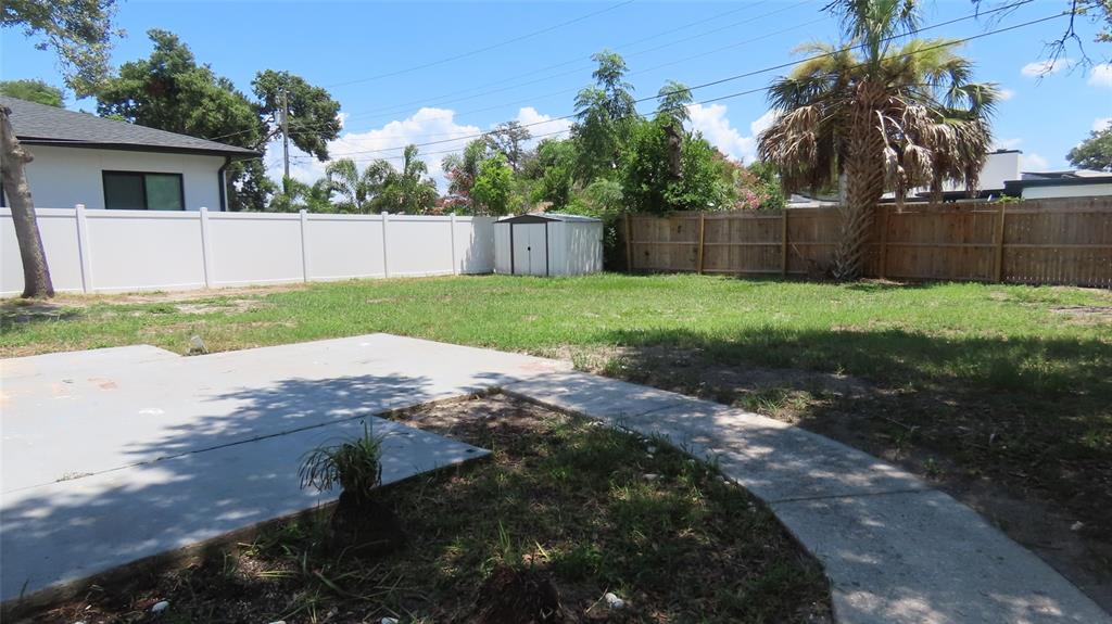 A backyard features a concrete patio, a small storage shed, and a mix of fencing — 4594 17TH AVENUE N, ST PETERSBURG, FL