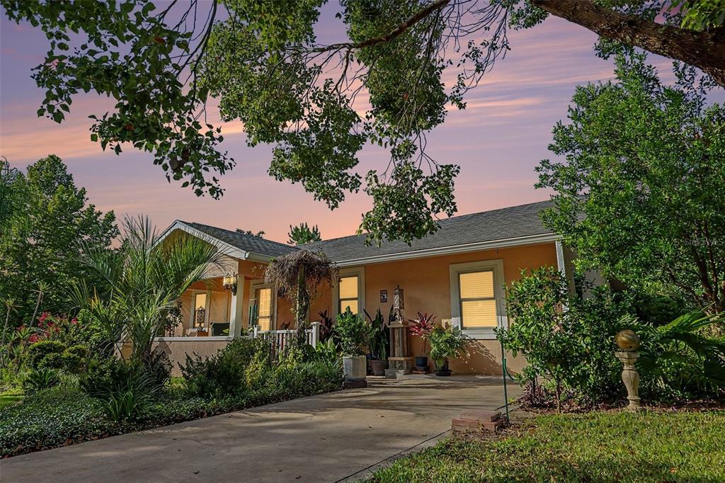 A single-story house with a peach-colored exterior, a front porch, and a concrete driveway — 7480 E HIGHWAY 25, BELLEVIEW, FL