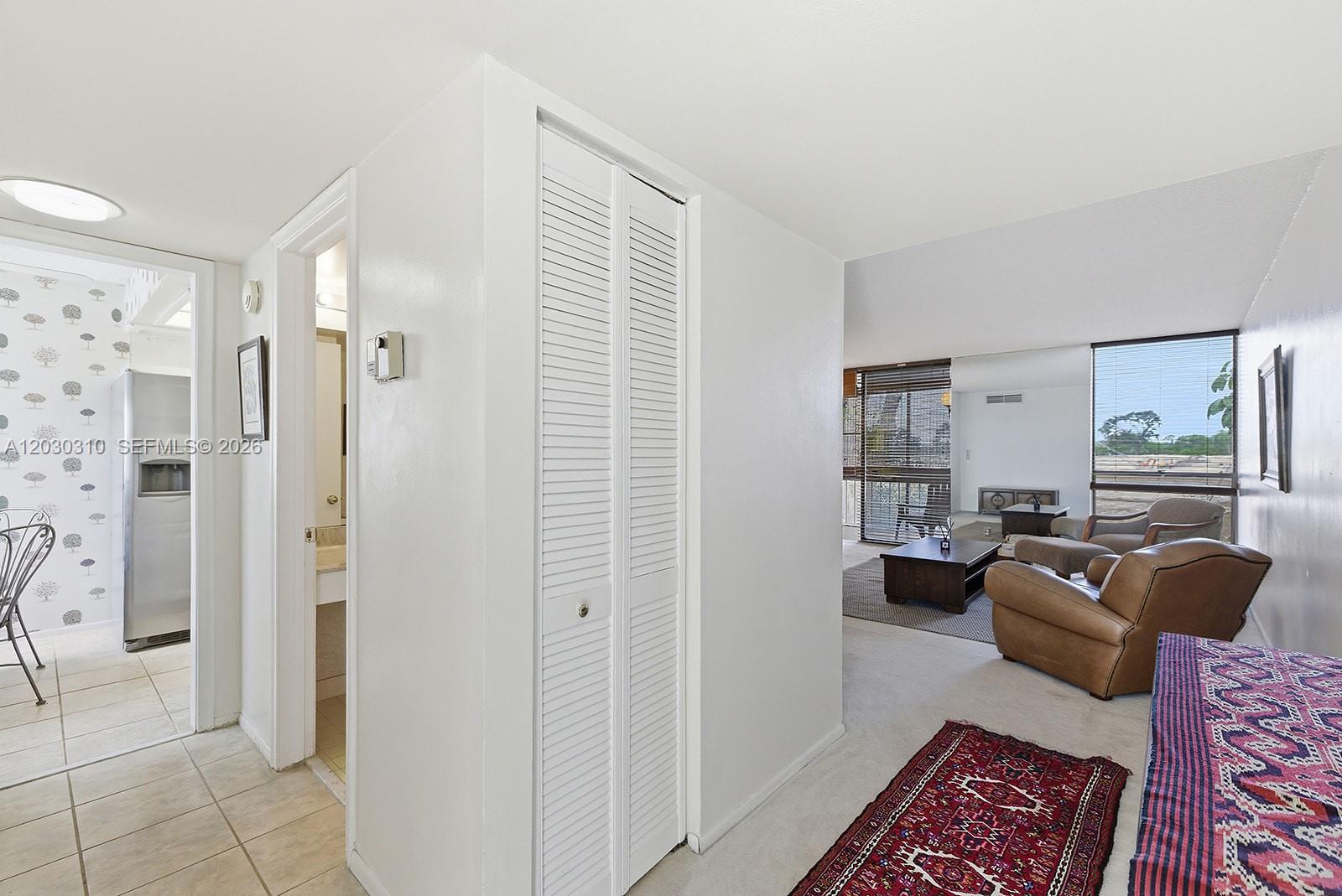 A view from a tiled hallway looking into a living room with carpeted floors — 1309 Bridgewood Dr, Boca Raton FL 33434, BOCA RATON, FL