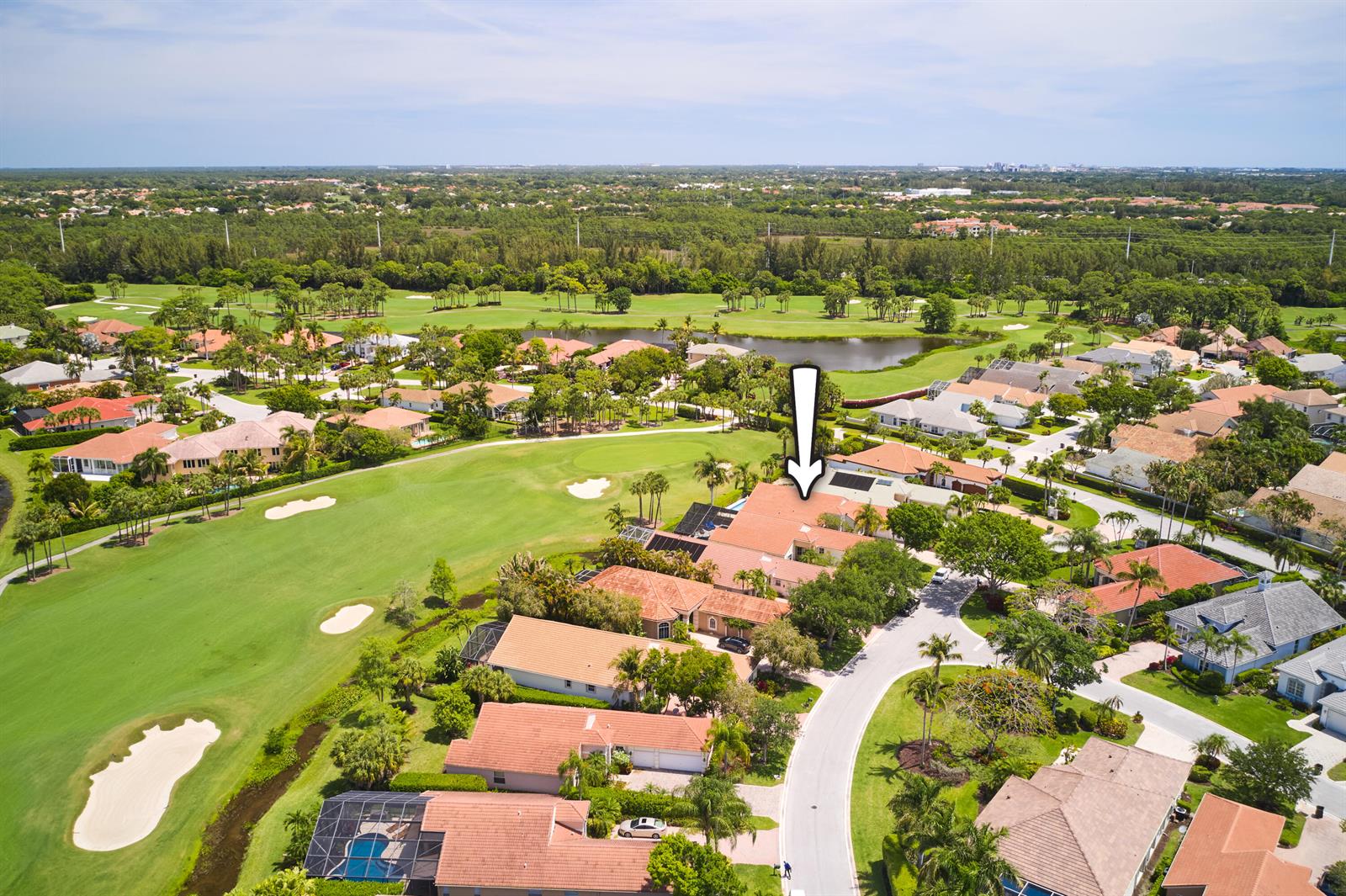 An aerial view shows a residential neighborhood with houses bordering a golf course and lake — 8282 Spyglass Drive, West Palm Beach FL 33412, WEST PALM BEACH, FL
