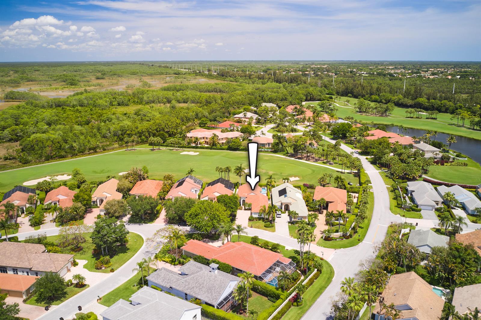 An aerial view shows a suburban neighborhood with houses surrounding a golf course — 8282 Spyglass Drive, West Palm Beach FL 33412, WEST PALM BEACH, FL