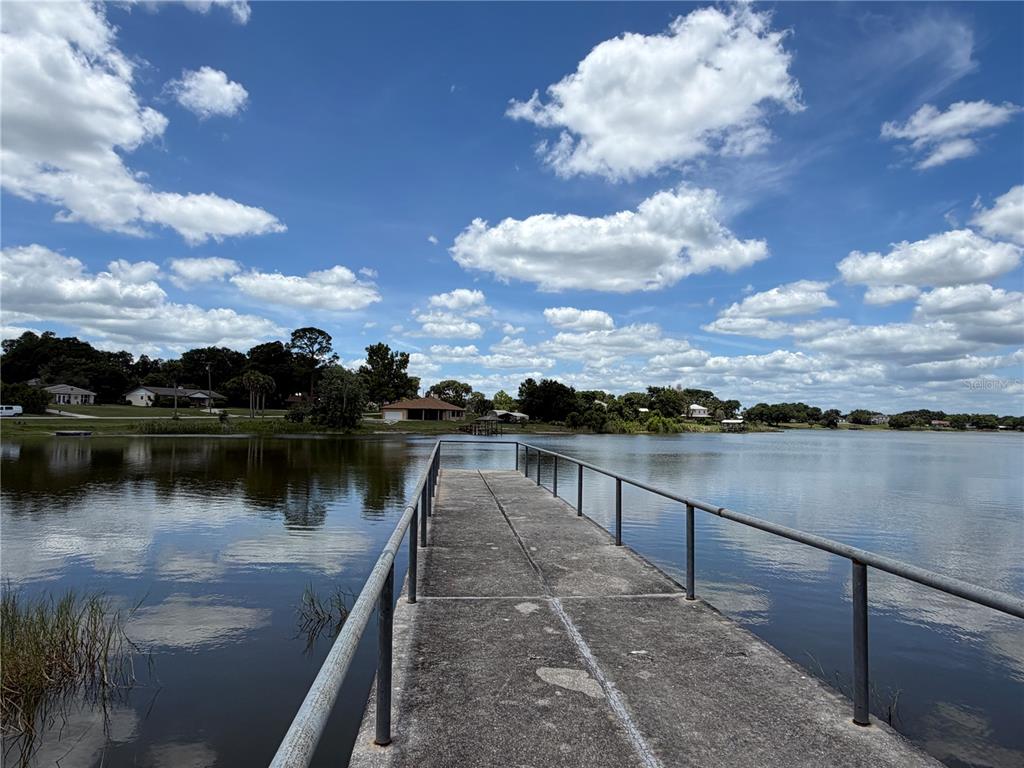 A concrete pier with metal railings extends into a lake under a cloudy sky — 0 LAKEVIEW STREET, UMATILLA, FL