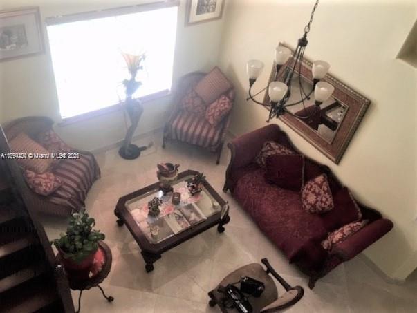 A high-angle view of a living room featuring a sofa, two armchairs, and a coffee table — 4854 NW 110th Pl, Doral FL 33178, DORAL, FL
