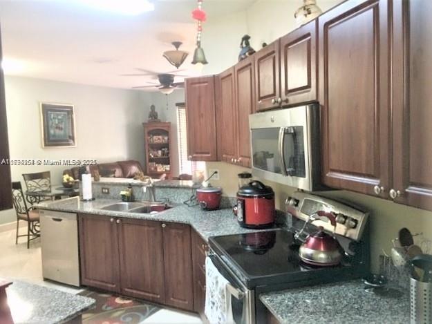 A kitchen features dark wood cabinets, granite countertops, and stainless steel appliances — 4854 NW 110th Pl, Doral FL 33178, DORAL, FL