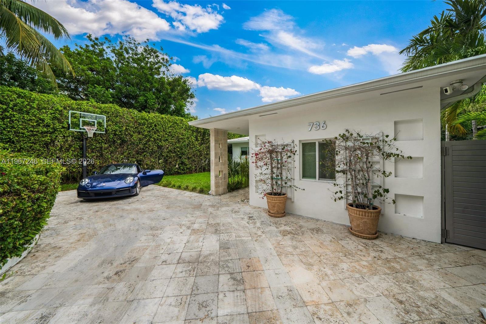 A paved driveway leads to a gated entrance surrounded by tall hedges and palm trees — 736 W 51 st, Miami Beach FL 33140, MIAMI BEACH, FL