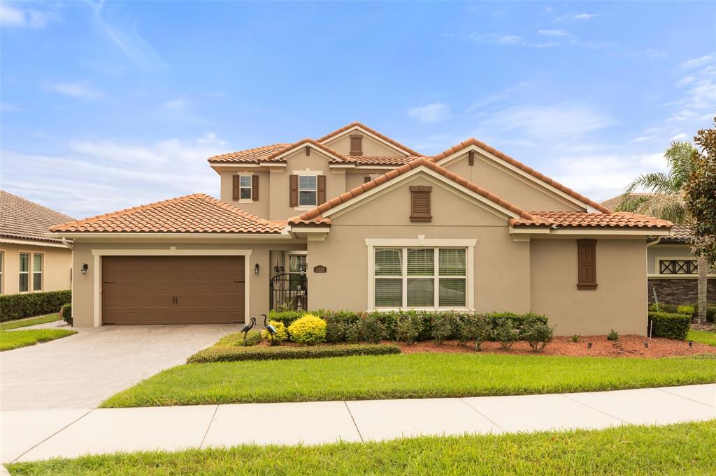 A two-story suburban house with a tan stucco exterior, tile roof, and attached garage — 3967 EQUINE COVE, LAKE MARY, FL