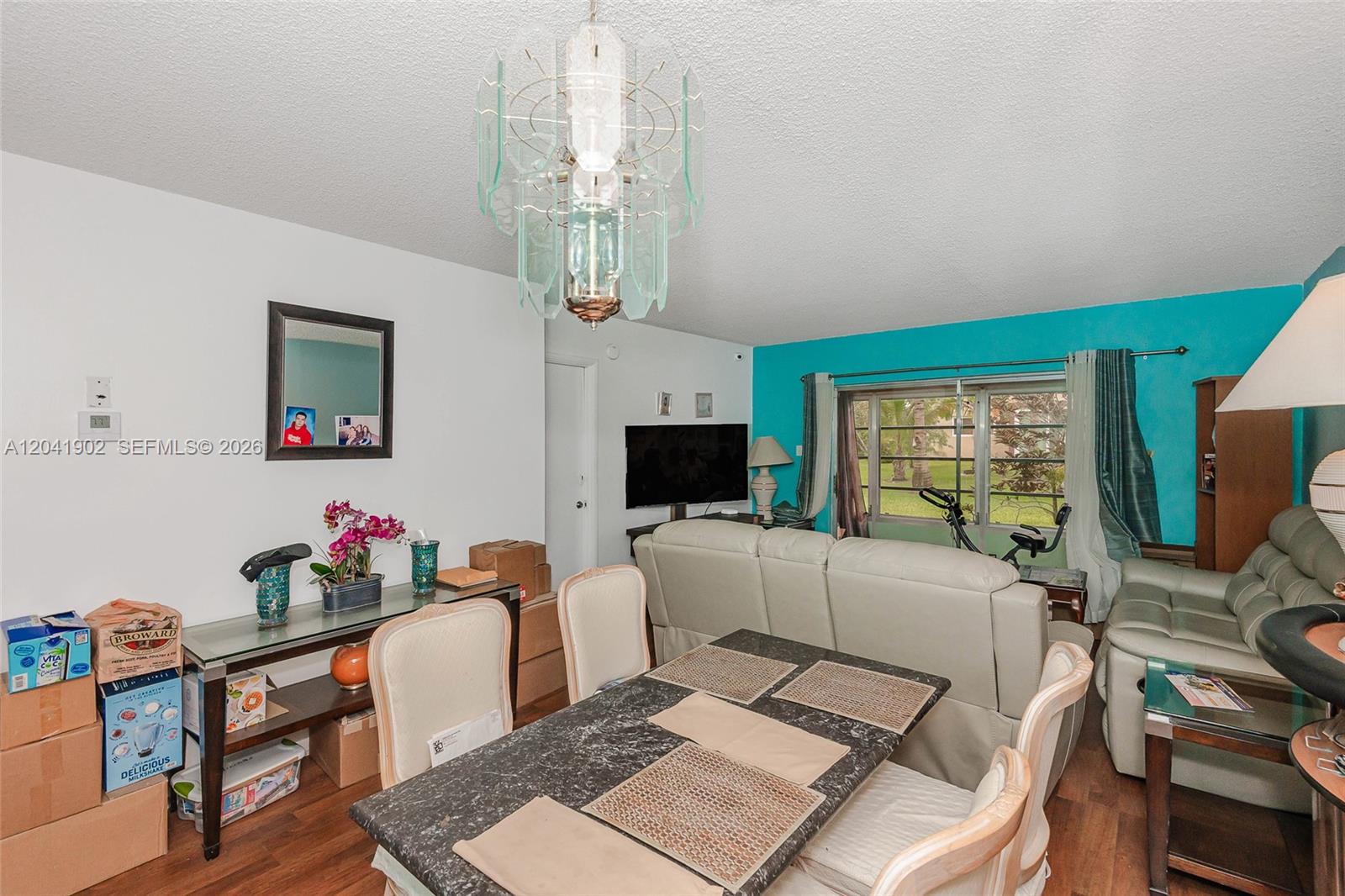 A dining area with a marble-top table sits in front of a living room space — 7200 NW 4th Pl # 101, Margate FL 33063, MARGATE, FL
