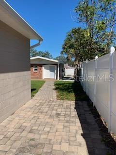 A paved walkway leads between a concrete block wall and a white vinyl fence — 2127 W PERIO STREET UNIT 1, TAMPA, FL