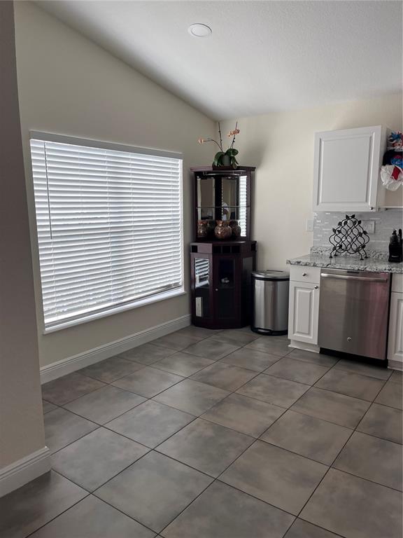 A kitchen area features tile flooring, white cabinets, a stainless steel dishwasher, and a corner hutch — 2127 W PERIO STREET UNIT 1, TAMPA, FL