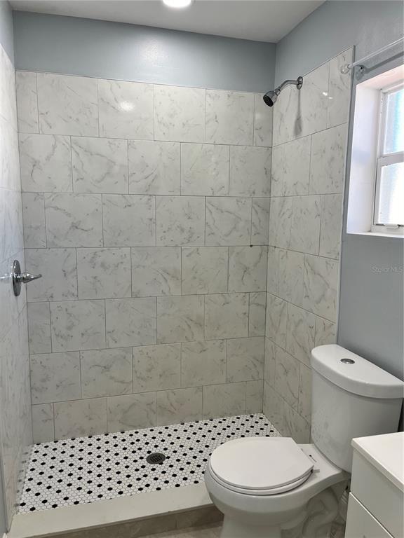 A bathroom features a walk-in shower with marble-look tile, a mosaic floor, and a toilet — 2127 W PERIO STREET UNIT 1, TAMPA, FL