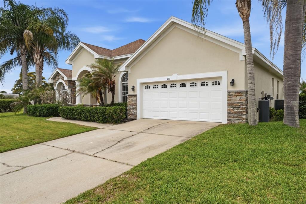 A living room with gray furniture, a nested coffee table, and a view of a pool — 200 LAKE ARIETTA COURT, AUBURNDALE, FL