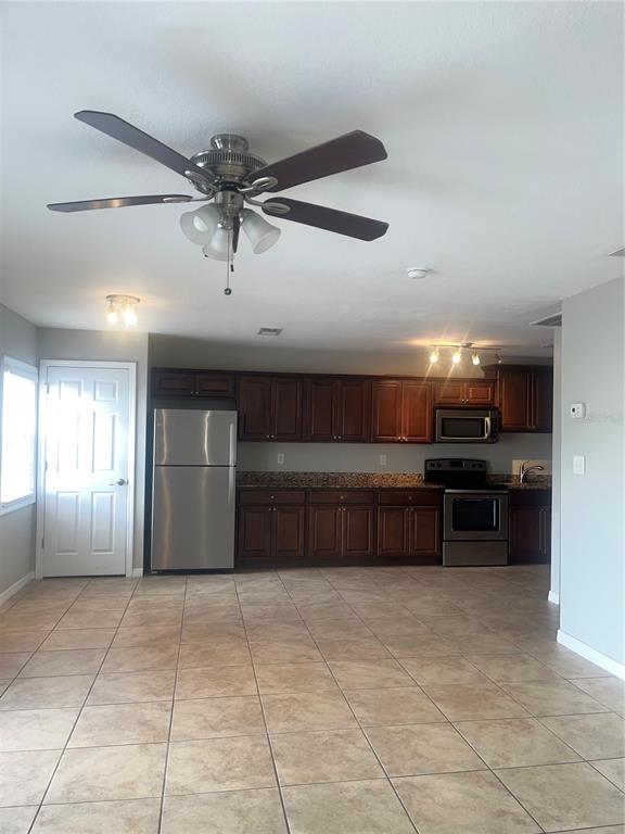 A kitchen with dark wood cabinets, stainless steel appliances, and tile flooring — 4728 BEACH DRIVE SE UNIT B, ST PETERSBURG, FL