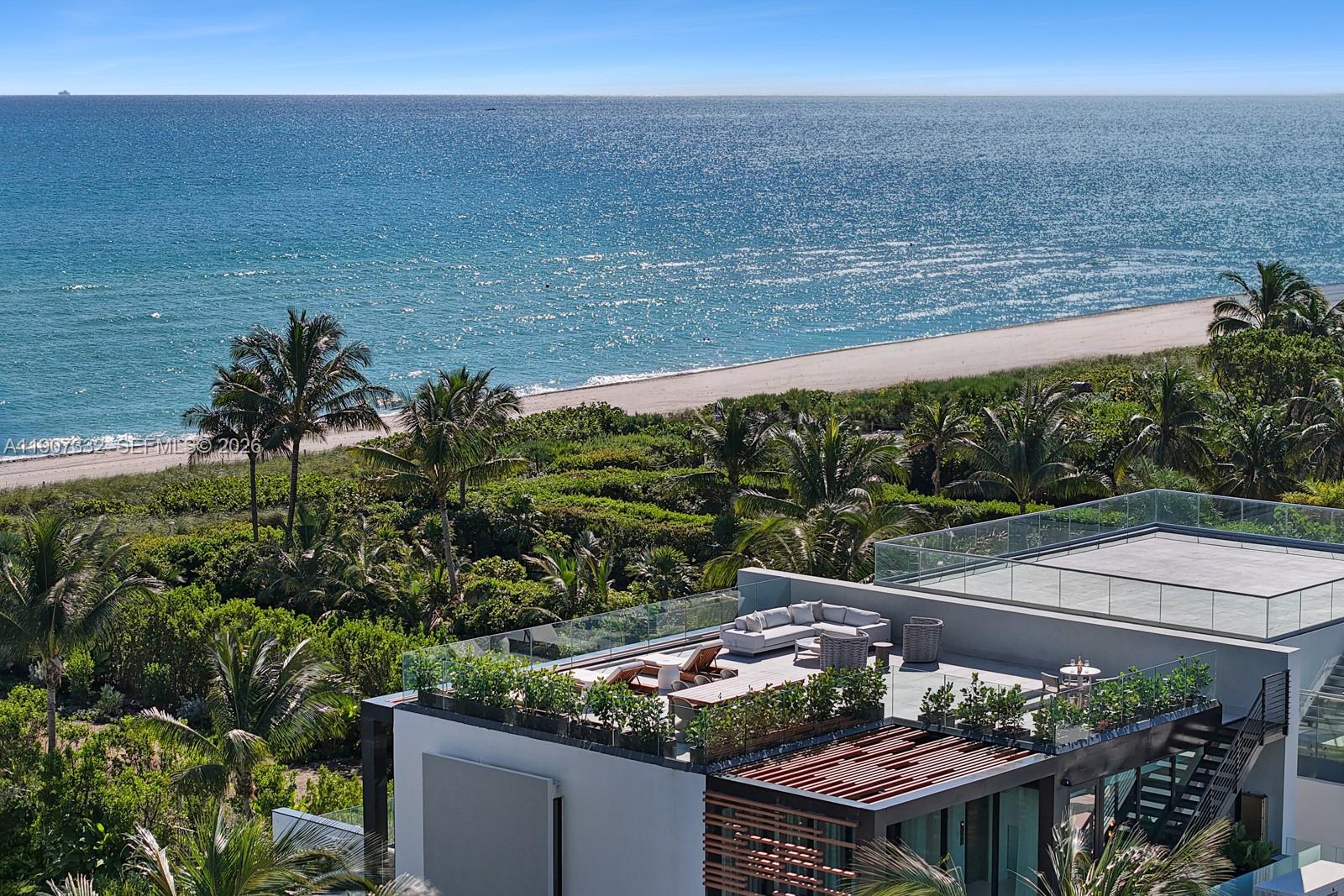 An elevated view of a modern building rooftop terrace overlooking a beach and ocean — 7845 Atlantic Way, Miami Beach FL 33141, MIAMI BEACH, FL