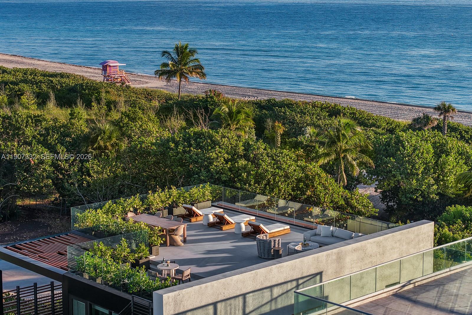 An elevated outdoor terrace features lounge chairs, dining furniture, and glass railings overlooking the ocean — 7845 Atlantic Way, Miami Beach FL 33141, MIAMI BEACH, FL