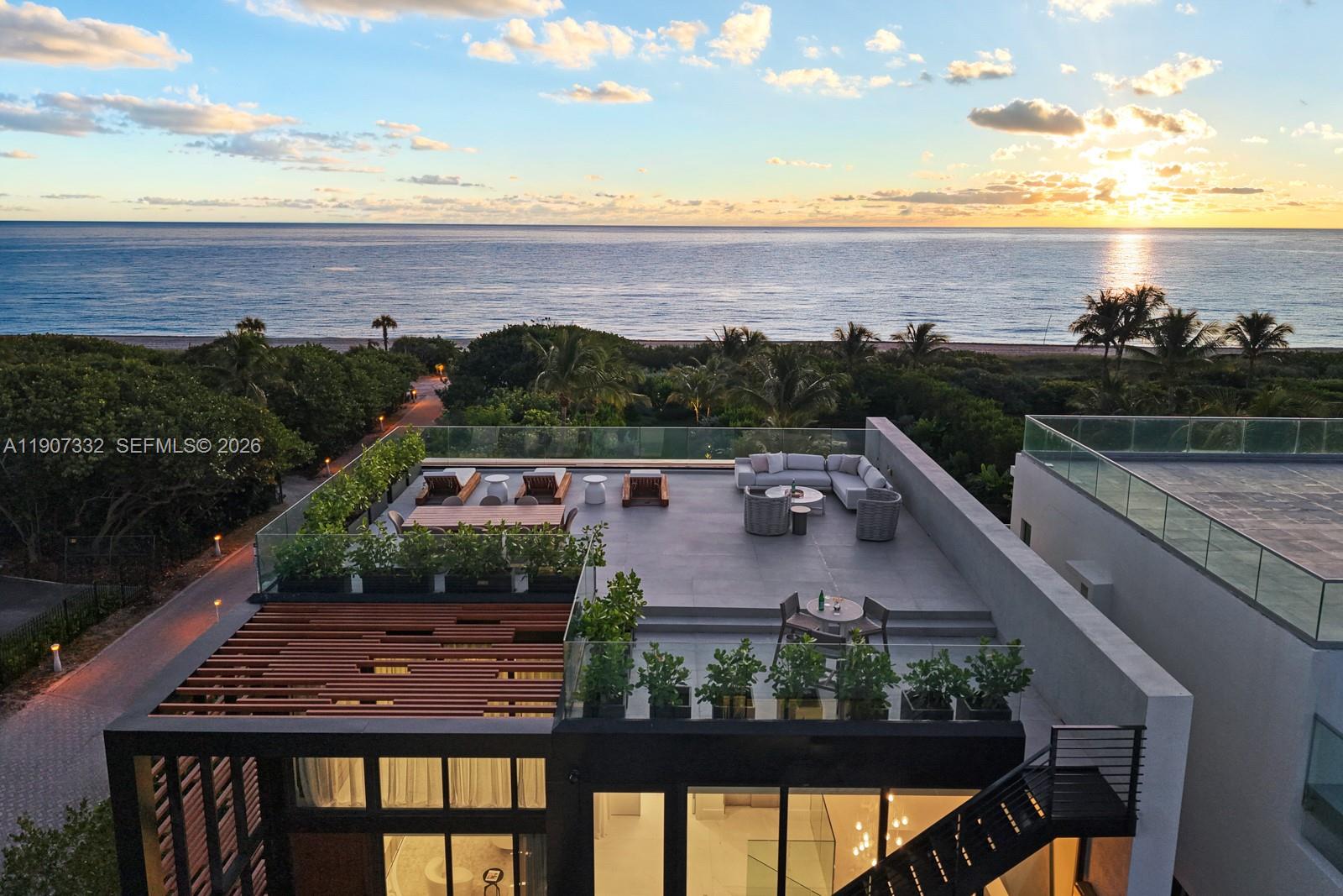 An aerial view shows a modern rooftop terrace with lounge seating overlooking the ocean — 7845 Atlantic Way, Miami Beach FL 33141, MIAMI BEACH, FL