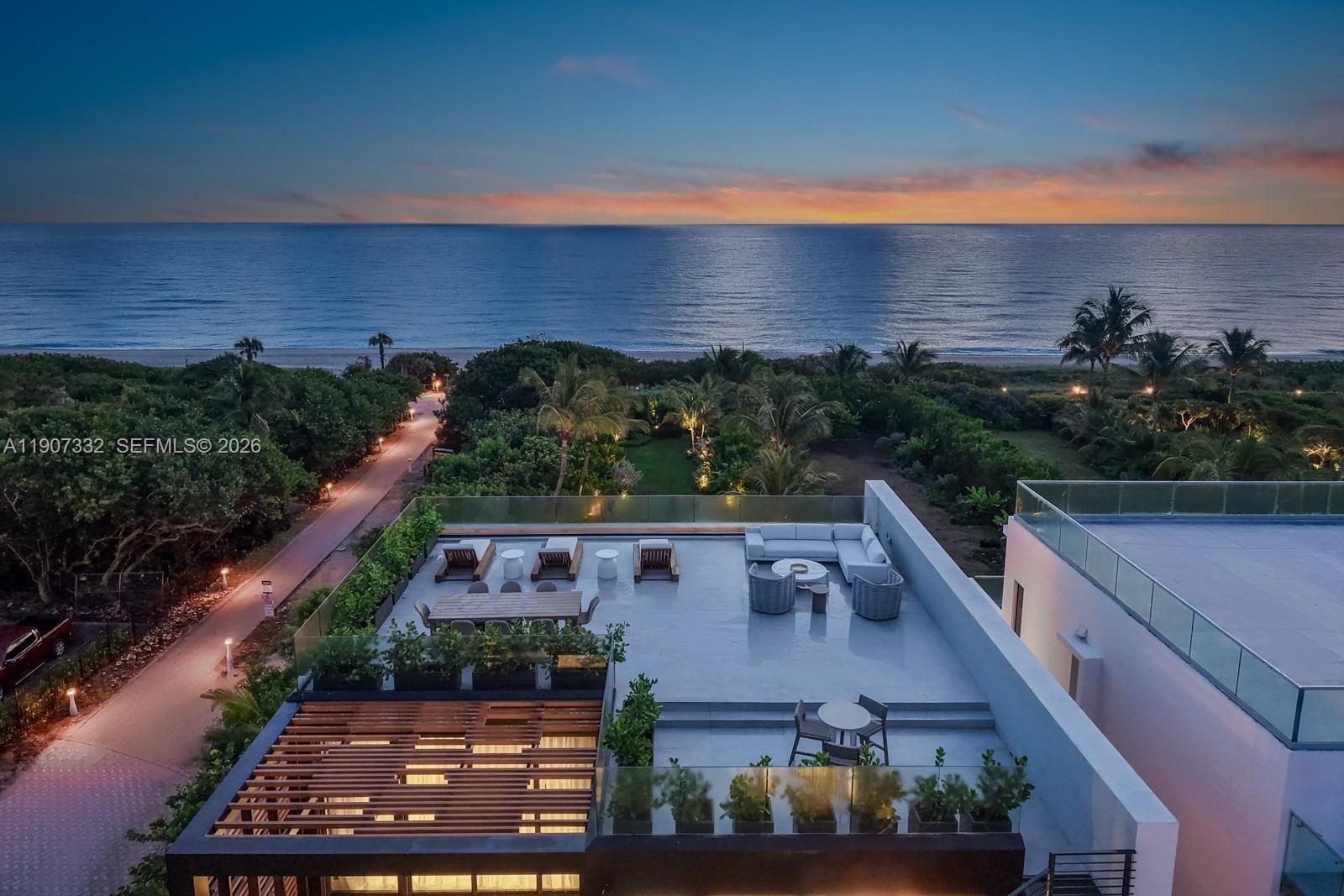 An elevated view of a modern rooftop terrace overlooking the ocean at sunset — 7845 Atlantic Way, Miami Beach FL 33141, MIAMI BEACH, FL