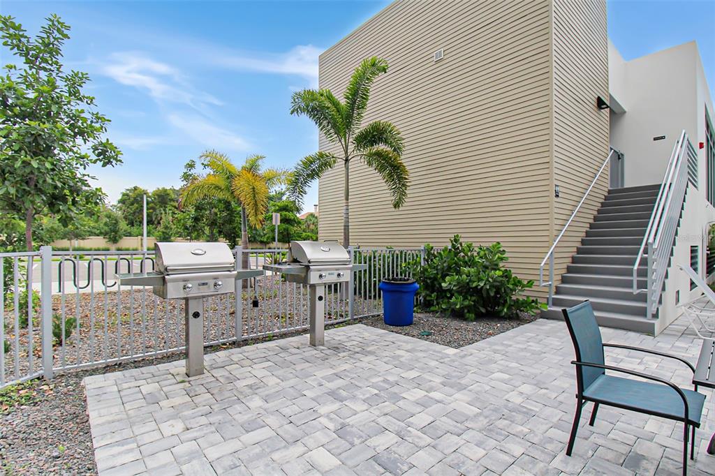 An outdoor patio area features two stainless steel grills, a blue trash bin, and stairs — 1703 N TAMIAMI TRAIL UNIT 503, SARASOTA, FL