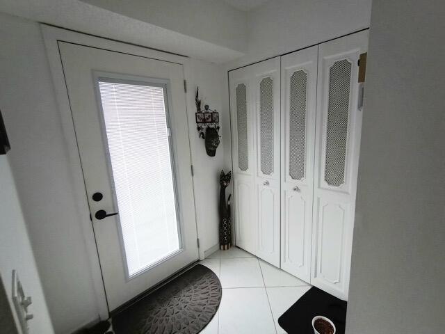 An entryway features a white front door, tiled floors, and a set of white closet doors — 1025 SE 4th Avenue # 101, Dania Beach FL 33004, DANIA BEACH, FL