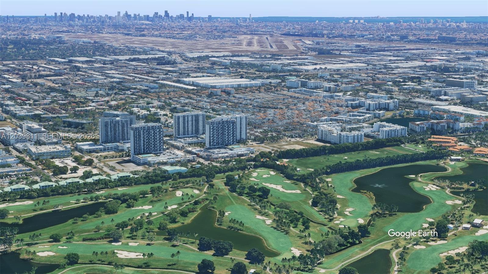 An aerial view shows a golf course in the foreground and city buildings in the distance — 5252 NW 85th Ave # 1504, Doral FL 33166, DORAL, FL