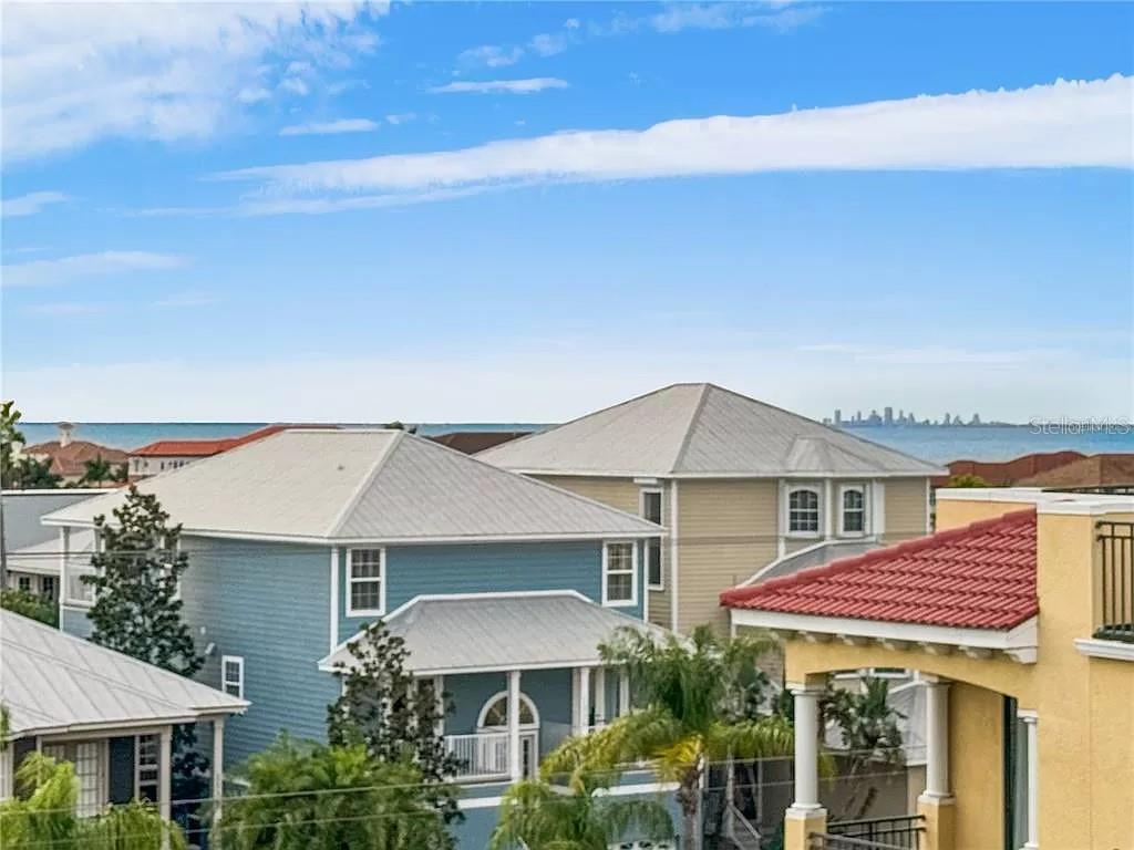 An elevated view shows several coastal houses with metal roofs near the ocean — 6418 MARGARITA SHORES LANE, APOLLO BEACH, FL