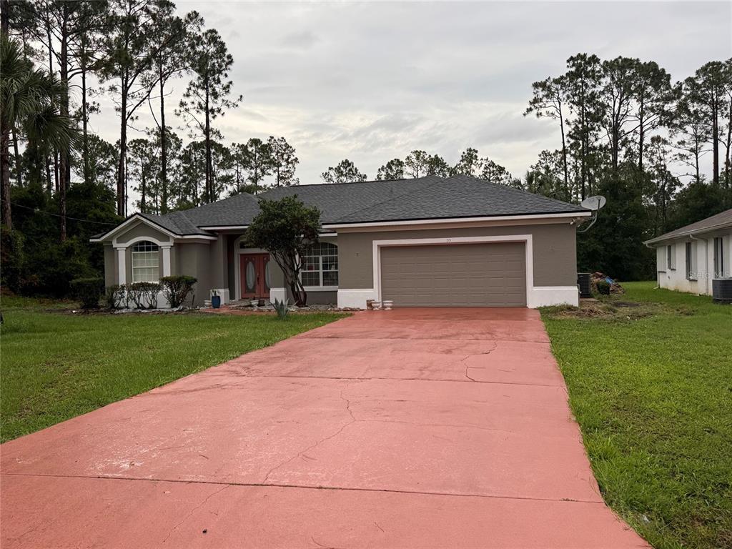 A single-story house with a red driveway, gray exterior, and a two-car garage — 33 WENDY LANE, PALM COAST, FL