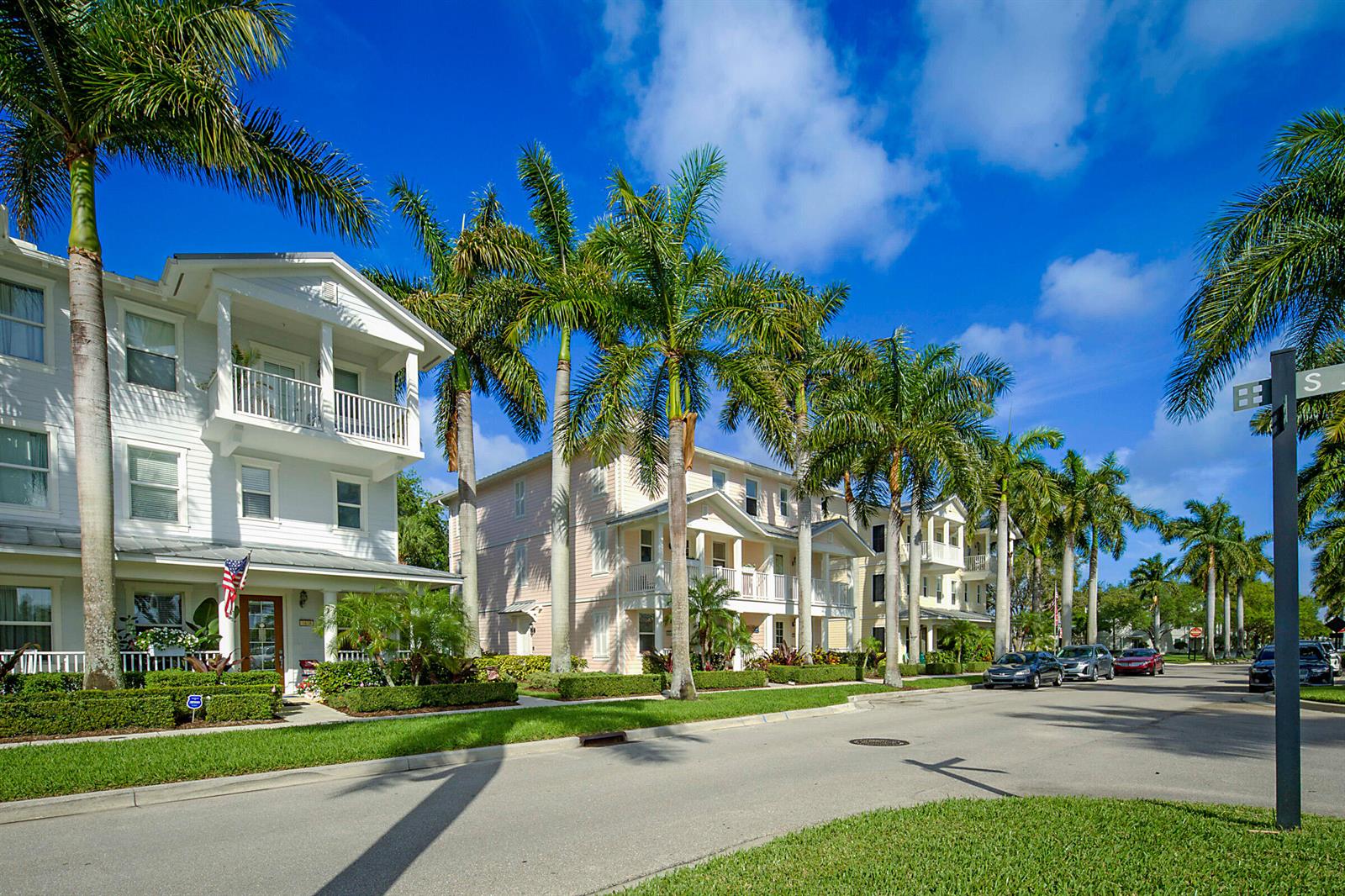 A street view of multi-story residential buildings with palm trees and parked cars — 3414 W Mallory Boulevard, Jupiter FL 33458, JUPITER, FL