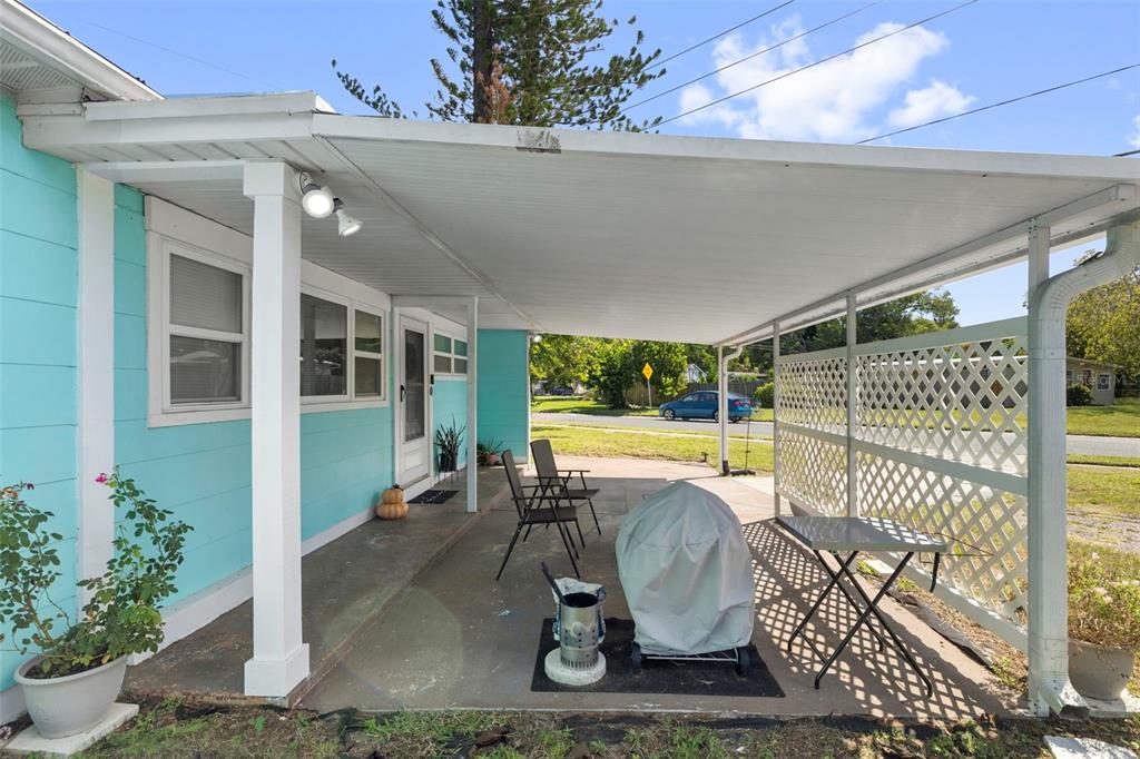 A covered patio with a concrete floor, lattice privacy screen, and outdoor furniture — 7001 13TH STREET N, ST PETERSBURG, FL