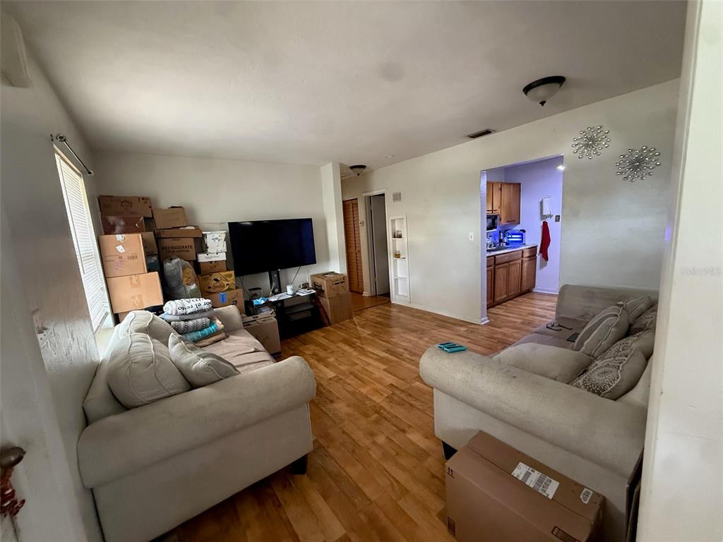 A living room with two sofas, a television, and a view into a kitchen — 21234 GLADIS AVENUE, PORT CHARLOTTE, FL