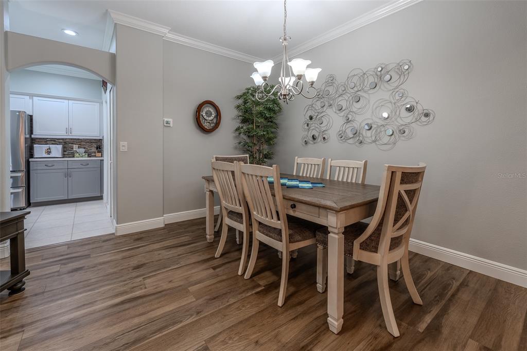 A dining room features a wooden table with six chairs, a chandelier, and wall art — 16364 SW 14TH COURT, OCALA, FL