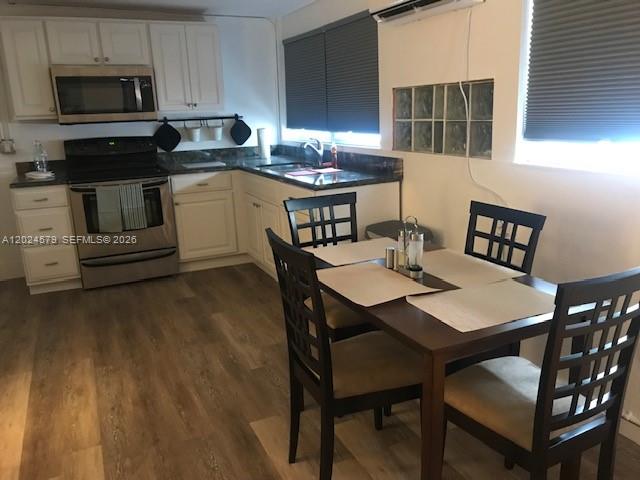 A kitchen with white cabinets, stainless steel appliances, and a wooden dining table with chairs — 923 SW 43 ave # 1, Miami FL 33134, MIAMI, FL