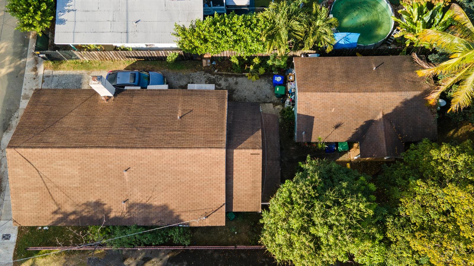 An aerial view shows two houses with brown shingled roofs, a driveway, and surrounding trees — 8111 NE 1st Avenue, Miami FL 33138, MIAMI, FL