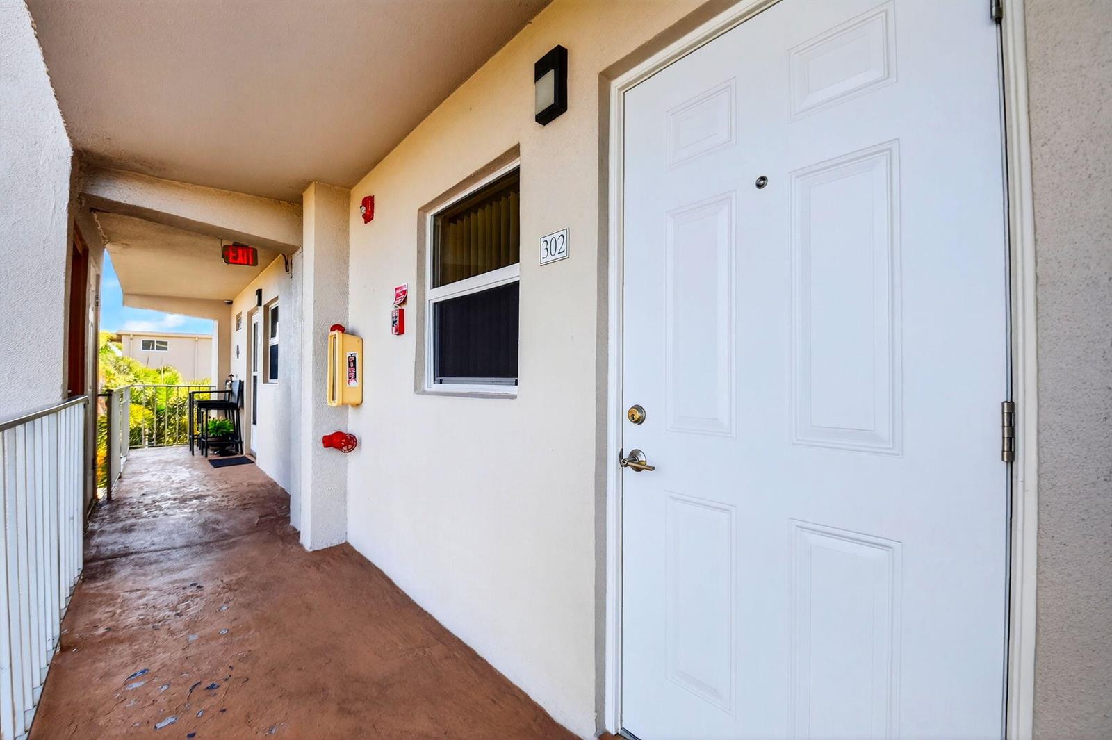 An exterior hallway shows a white apartment door numbered 302, a window, and fire equipment — 230 NE 26th Avenue # 3020, Boynton Beach FL 33435, BOYNTON BEACH, FL