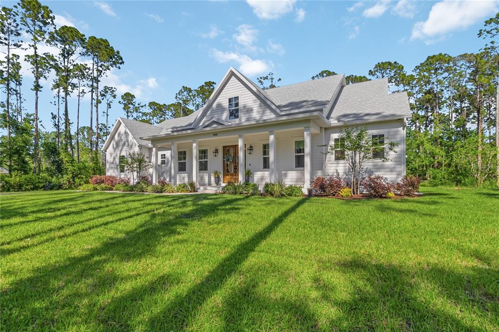 A white, single-story house with a covered front porch sits on a grassy lawn — 3805 LAKEVIEW ACRES ROAD, ST CLOUD, FL