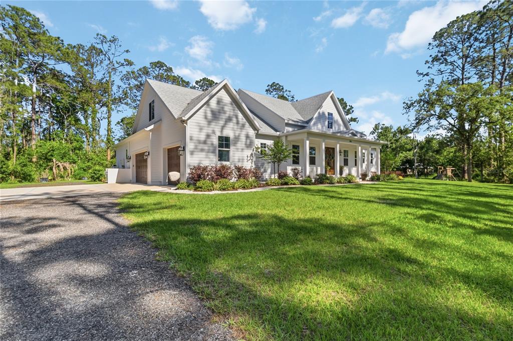 A white two-story house with a gray shingled roof sits on a grassy lot — 3805 LAKEVIEW ACRES ROAD, ST CLOUD, FL
