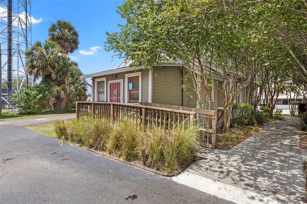A small, tan, single-story house with a wooden wheelchair ramp and a paved walkway — 5135 N FLORIDA AVENUE, TAMPA, FL