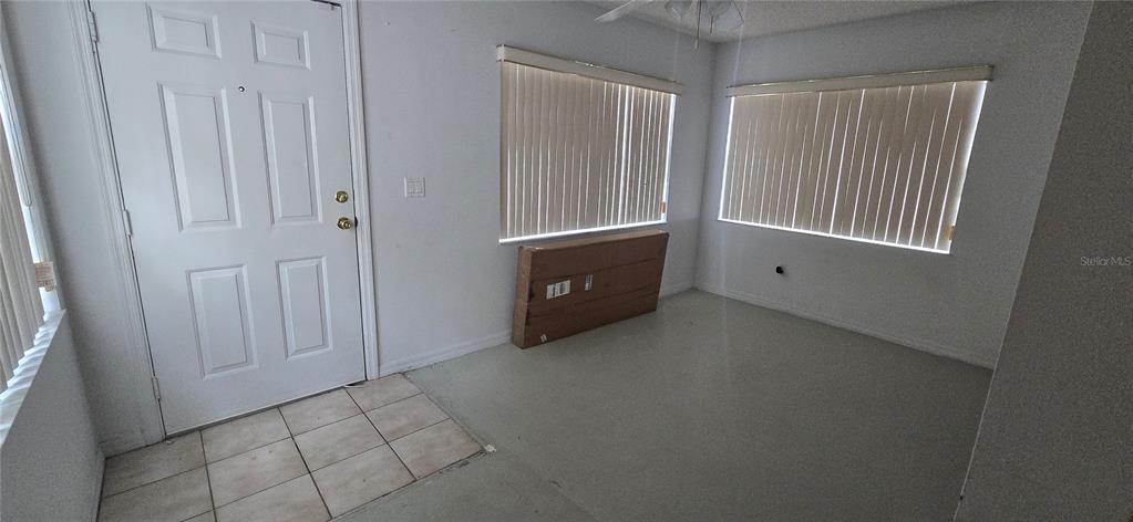 An entryway with a white door, tiled floor, and two windows with vertical blinds — 545 CLARK STREET, MAITLAND, FL