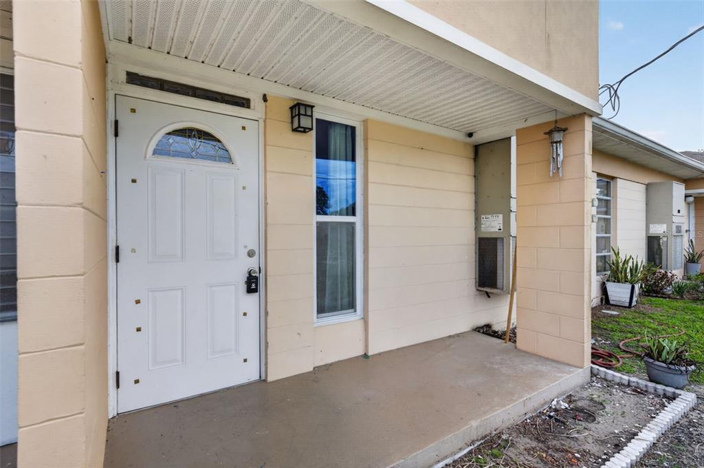 A white front door with a decorative window sits on a covered concrete porch — 3111 CLUB CIRCLE, LAKE WALES, FL