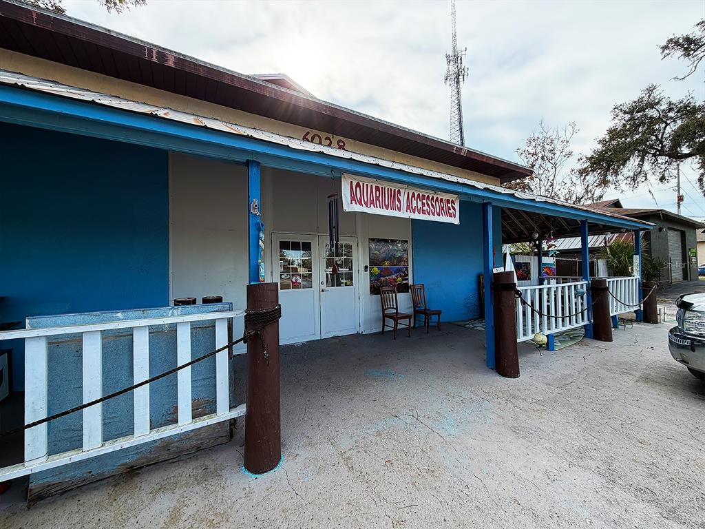 The exterior of a blue building features a sign for aquariums and accessories — 6028 PINE HILL ROAD, PORT RICHEY, FL