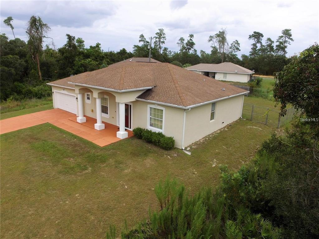 An aerial view of a single-story beige house with a brown roof and orange driveway — 15747 SW 47TH AVENUE ROAD, OCALA, FL