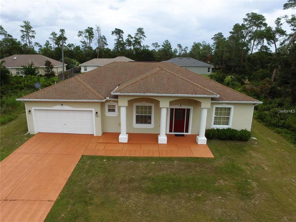 An aerial view of a single-story house with a tan exterior, brown roof, and garage — 15747 SW 47TH AVENUE ROAD, OCALA, FL