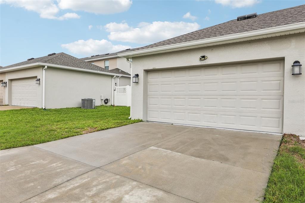 A view of a concrete driveway leading to a two-car garage of a suburban home — 13926 TITLE WAY, WINTER GARDEN, FL