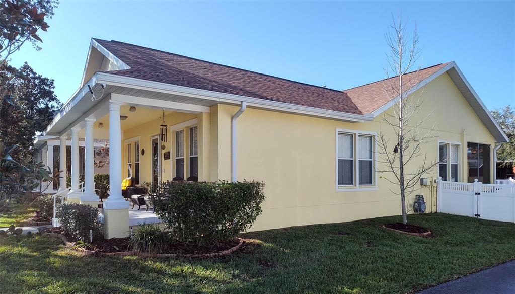 A yellow house with a covered front porch, white columns, and a brown shingled roof — 3639 HURSTON STREET, NEW PORT RICHEY, FL