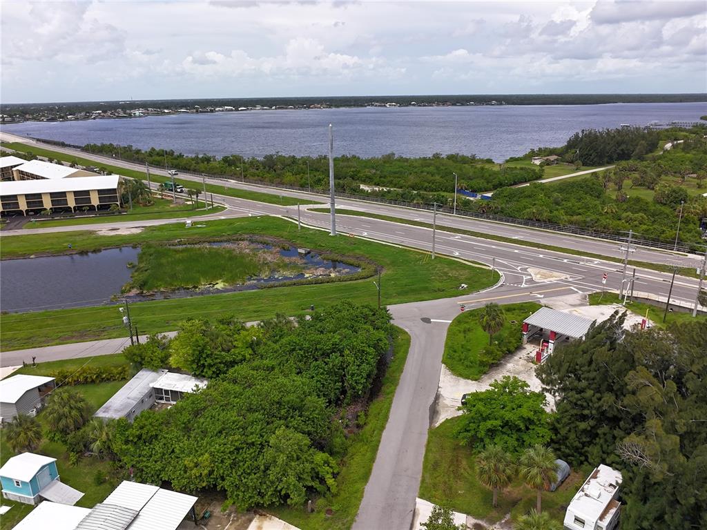 An aerial view shows a road intersection, a small pond, and nearby residential properties — 4572 STURKIE AVENUE, PORT CHARLOTTE, FL