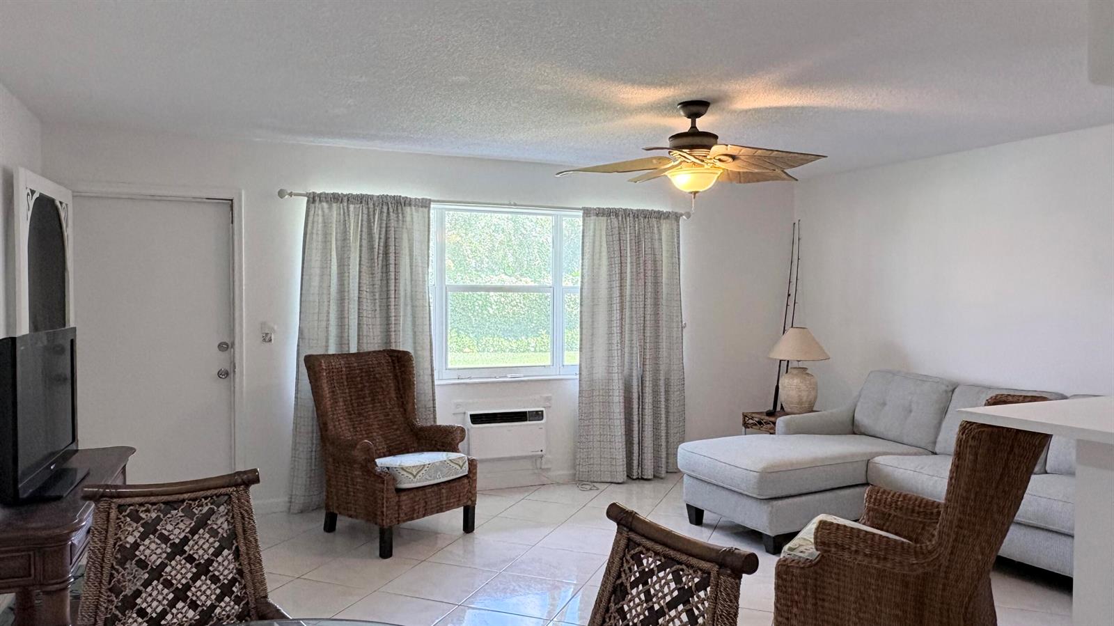 A living room features a light gray sectional sofa, wicker armchairs, and a ceiling fan — 200 Horizon W # 102, Boynton Beach FL 33435, BOYNTON BEACH, FL