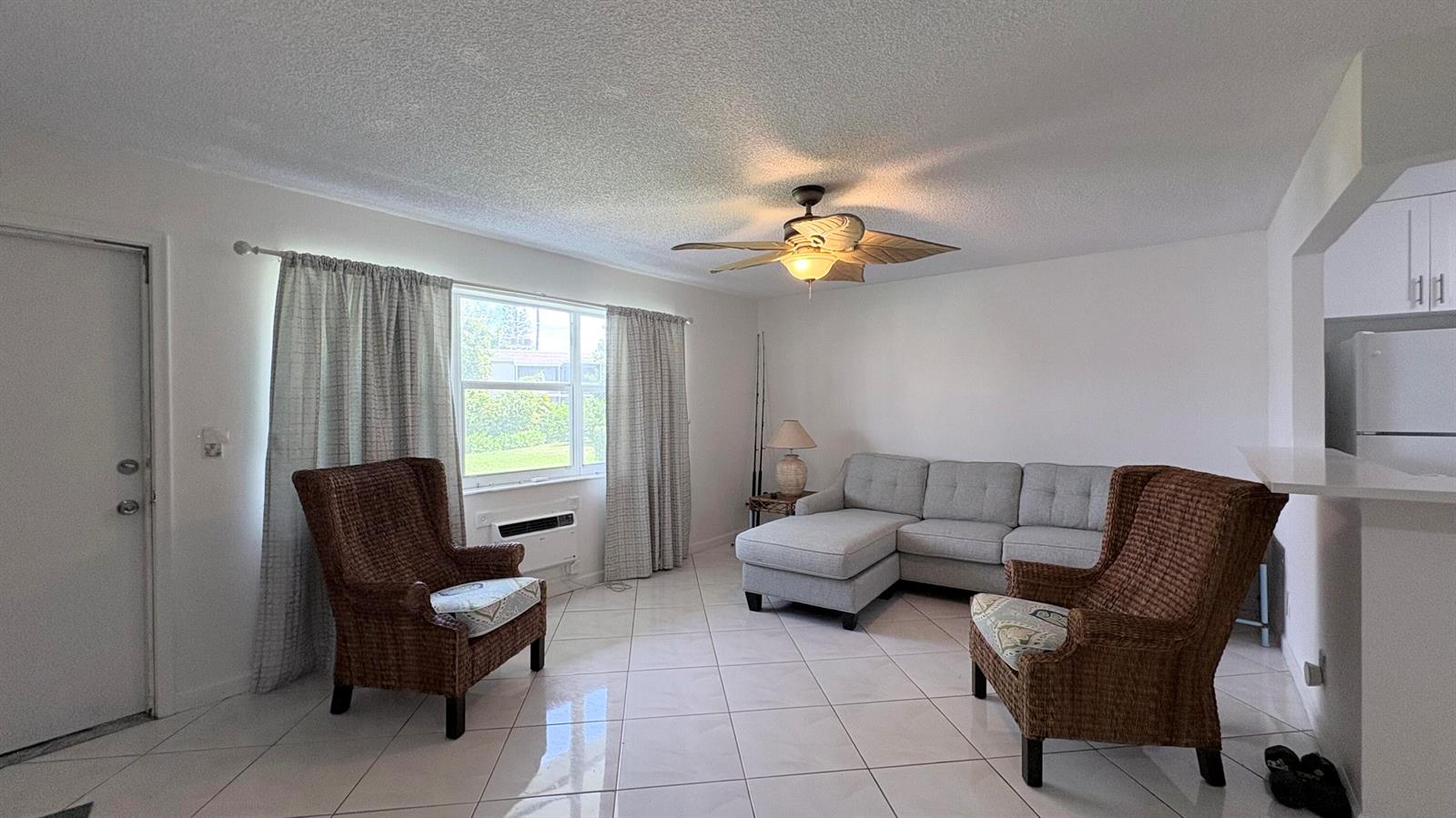 A living room features white tile floors, a gray sectional sofa, and two wicker armchairs — 200 Horizon W # 102, Boynton Beach FL 33435, BOYNTON BEACH, FL