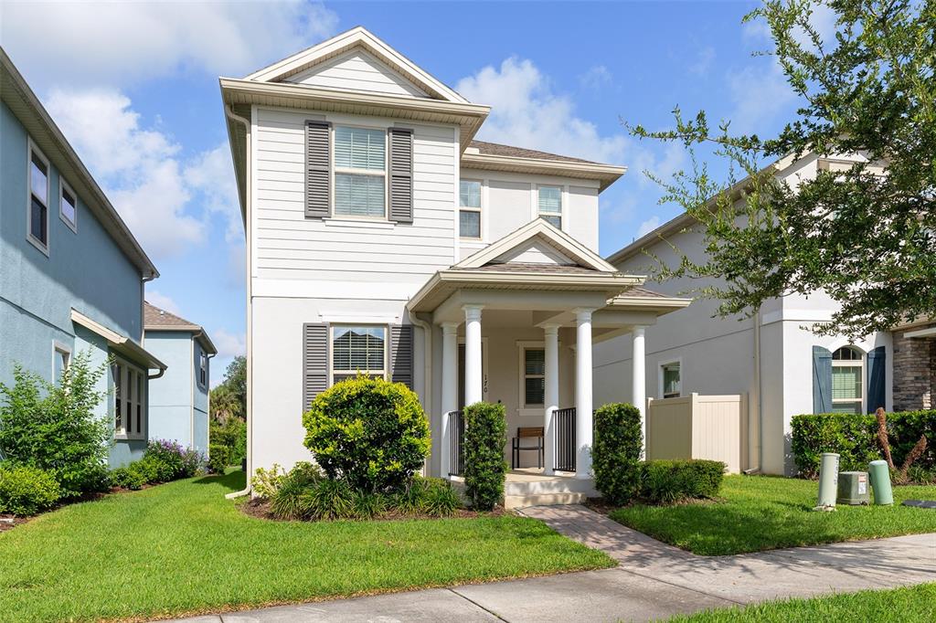 A two-story house with white siding, a covered front porch, and a green lawn — 170 WOODED VINE DRIVE, WINTER SPRINGS, FL