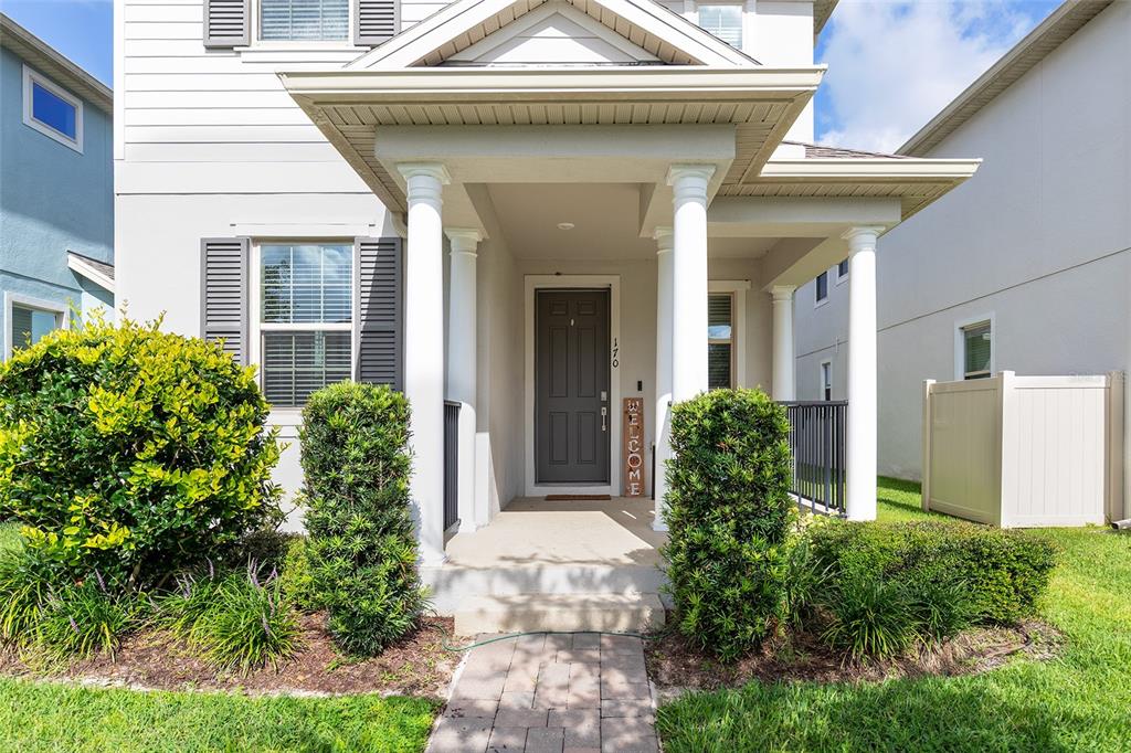 The exterior of a two-story house features a covered front porch with white columns — 170 WOODED VINE DRIVE, WINTER SPRINGS, FL